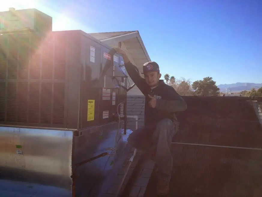 HVAC technician performing Air Duct Cleaning on a rooftop unit in Thompson's Station
